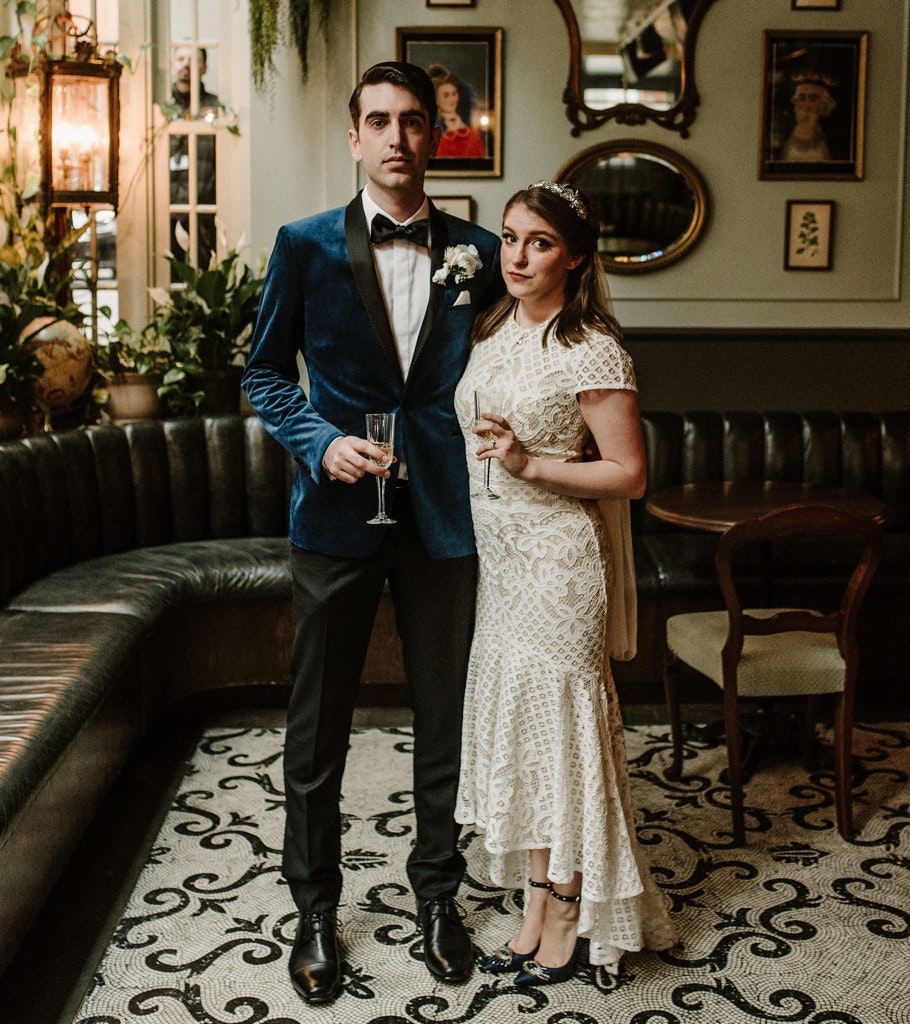 A wedding couple pose in front of Kittyhawk's artwork.